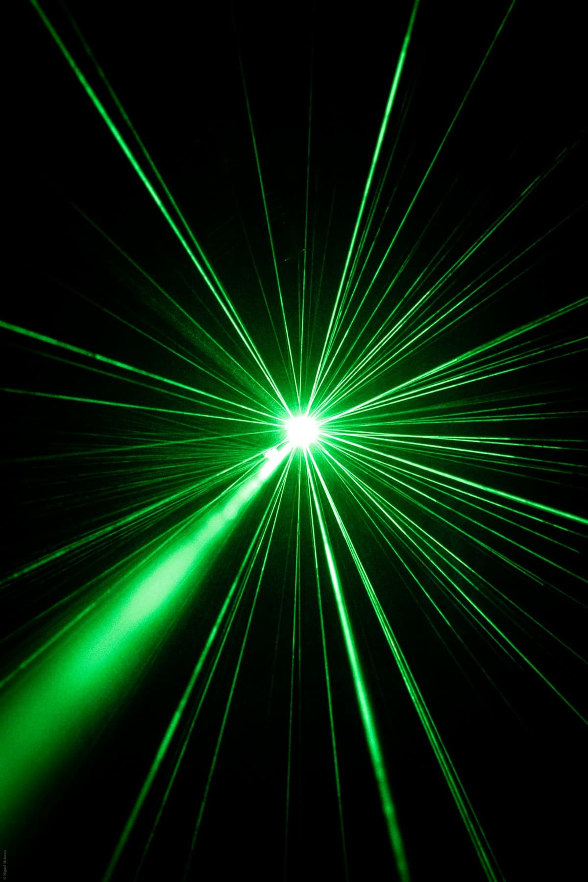 Green laser beams radiating from a central point